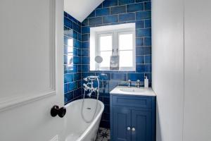 a blue tiled bathroom with a tub and a sink at 3 Bed in Kelling oc-w27424 in Kelling +17 photos