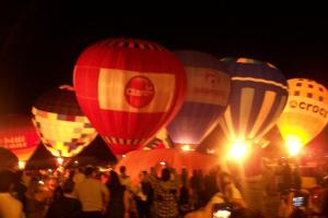 a group of hot air balloons at night at Cabanas das Oliveiras in Torres +40 photos