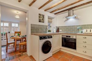 a kitchen with a washing machine and a table at 2 Bed in Lavenham oc-s30055 in Lavenham