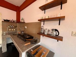 a kitchen with a counter with a stove and shelves at Avalokiteśvara Āvāsa in Kathmandu +13 photos