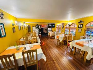 a restaurant with tables and chairs and yellow walls at Hostal La Posada De La Abuela in La Paz