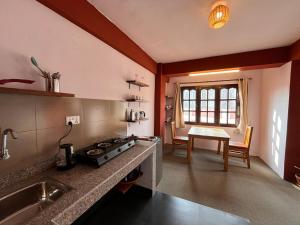 a kitchen with a stove and a table in it at Avalokiteśvara Āvāsa in Kathmandu