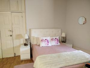 a bedroom with a bed with pink and white pillows at 4-As Andar-Moradia Castelo in Guimarães