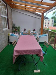 a table and chairs on a patio with green grass at 4-As Andar-Moradia Castelo in Guimarães