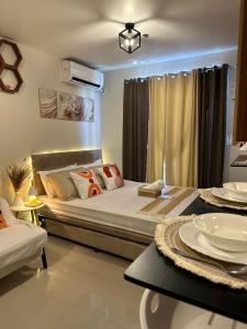 a bedroom with a large bed and a table at staycaSHAWN studio in Lapu Lapu City +28 photos
