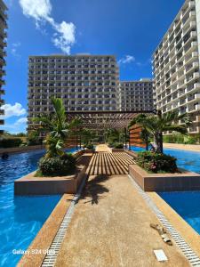 a large building with palm trees and a swimming pool at staycaSHAWN studio in Lapu Lapu City