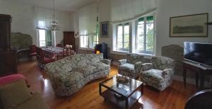 a living room with couches and a table and a television at B&B Cortebonomini apartment in Neviano degli Arduini