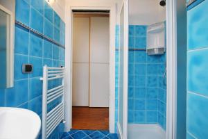 a blue tiled bathroom with a shower and a toilet at WI-RO Carminati - Mare e relax in Marina di Andora