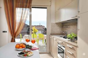 a kitchen with a table with a bowl of fruit at WI-RO Carminati - Mare e relax in Marina di Andora