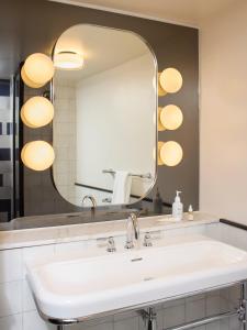 a bathroom with a sink and a large mirror at The Hoxton, Shoreditch in London +32 photos