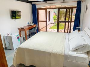 a bedroom with a bed and a desk and a window at ARAUCARIA RESIDENCE in Gisenyi