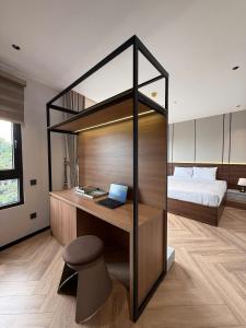a bedroom with a bed and a desk with a laptop at Ama Retreat in Buôn Enao +5 photos