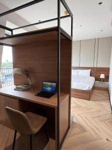 a bedroom with a bunk bed with a laptop on a desk at Ama Retreat in Buôn Enao