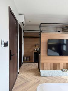 a living room with a large tv and a door at Ama Retreat in Buôn Enao