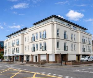a white building on the corner of a street at Roomspace Serviced Apartments - Trinity House in Reigate