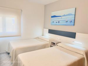 a hotel room with two beds and a painting on the wall at Apartamento Mardevela in Sanxenxo