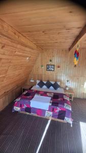 a bedroom with a bed in a wooden room at Pinehill cottage in Jibhi