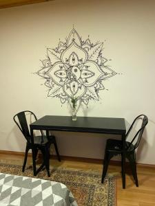 a black table with a flower mandala stencil on a wall at Hermoso Loft Amoblado Sector Oriente Talca in Talca