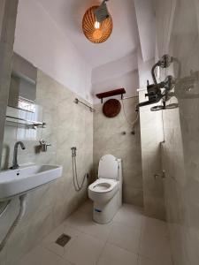 a bathroom with a toilet and a sink and a shower at Mandāravā Āvāsa in Kathmandu