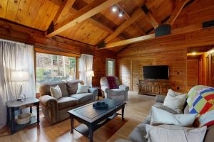 a living room with couches and a tv in a cabin at 4-Season Family Base! 13 Mi to Lake Winnipesaukee in Center Barnstead