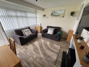 a living room with two couches and a flat screen tv at 192, Two bed newly refurbished chalet on Sund0wner Holiday Park - Sleeps 5, pet friendly - Includes electricity, bed linen and towels - Entertainment options close by in Hemsby