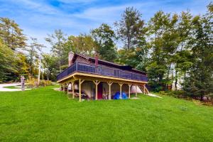 a house on top of a grassy hill at 4-Season Family Base! 13 Mi to Lake Winnipesaukee in Center Barnstead