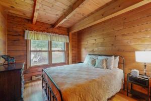 a bedroom with a bed in a log cabin at 4-Season Family Base! 13 Mi to Lake Winnipesaukee in Center Barnstead