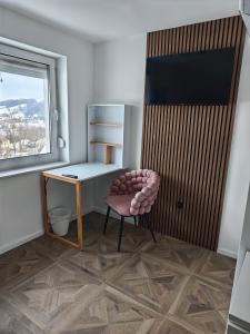 ein Zimmer mit einem Stuhl, einem Schreibtisch und einem Fenster in der Unterkunft Sleepoteca in Šentilj
