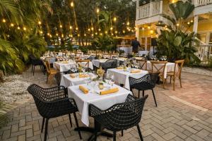 a restaurant with white tables and chairs and lights at Peninsula Bed & Cocktails in St. Petersburg