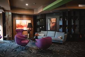 a living room with purple chairs and a couch at Hotel Arka in Skopje +37 photos