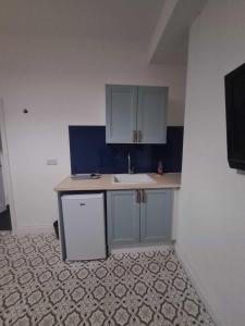 a small kitchen with a sink and blue cabinets at Sunderland Stadium Studios in Sunderland