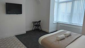 a bedroom with a bed and a flat screen tv at Sunderland Stadium Studios in Sunderland
