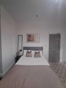 a bedroom with a large white bed with two pillows at Sunderland Stadium Studios in Sunderland