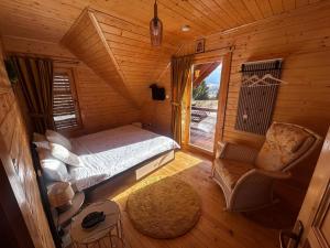 a bedroom with a bed and a chair in a cabin at Casa Dani in Vatra Dornei
