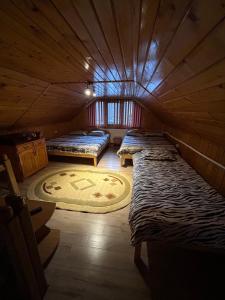a room with three beds in a wooden cabin at Casa de vacanța Cristina in Cîmpu lui Neag