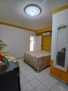 a bedroom with a bed and a refrigerator at Aconchego de Olinda in Olinda