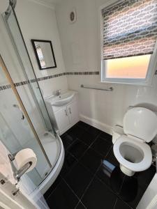 a bathroom with a toilet and a shower and a sink at 145, Two bed newly refurbished chalet on Sund0wner Holiday Park - Sleeps 5, pet friendly - Includes bed linen and towels plus electricity in Great Yarmouth +8 photos