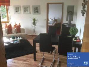 a living room with a couch and a table and chairs at Ferien Wohnung Sonnenschein in Wechterswinkel