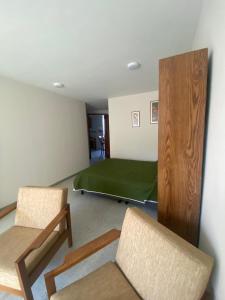 a room with a bed and two chairs in it at Siéntete en casa 2 in Pasto