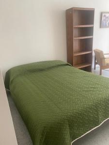 a bed with a green comforter in a bedroom at Siéntete en casa 2 in Pasto
