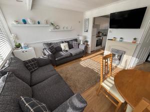 a living room with a couch and a table at 145, Two bed newly refurbished chalet on Sund0wner Holiday Park - Sleeps 5, pet friendly - Includes bed linen and towels plus electricity in Great Yarmouth
