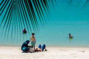 a group of people on a beach with the water at Perhentian Island Resort in Perhentian Islands