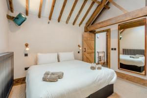 a bedroom with a large white bed with a mirror at 5 Bed in Kings Lynn oc-96250 in Clenchwarton +47 photos
