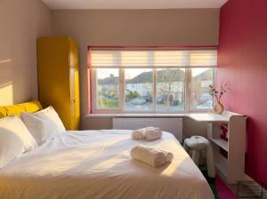 a bedroom with a bed with two towels on it at Zozy Clitterhouse in London