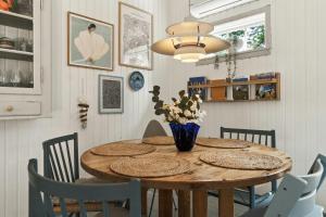 a dining room table with chairs and a vase of flowers at Cozy Summerhouse On Bornholm in Vester Sømarken