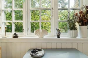 a window sill with a book and a cat statue at Cozy Summerhouse On Bornholm in Vester Sømarken