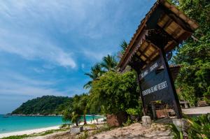 a sign on a beach near the ocean at Perhentian Island Resort in Perhentian Islands