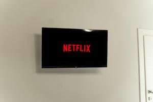 a tv on a wall with the netflix sign on it at Palazzo Margò - Private Luxury Palace with Sea View in Mola di Bari +37 photos