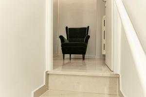 a black chair sitting in the middle of a hallway at Palazzo Margò - Private Luxury Palace with Sea View in Mola di Bari