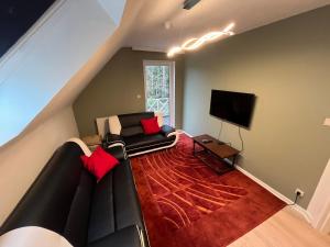 a living room with a couch and a flat screen tv at Silk and Stone Manor in Grez-Doiceau